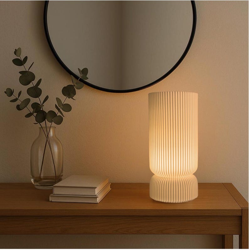 Decorative lamp on a wooden surface with a mirror and vase in the background