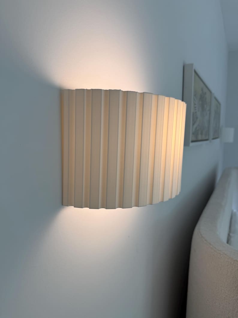 Wall-mounted lamp with pleated shade on a white wall